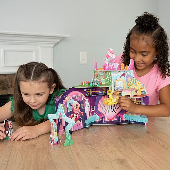 Two girls playing with a mermaid castle toy set on a kitchen table. Puzzle, Craft, Storybook and Playset all in one